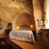 Anitya Cave House in Ürgüp cave-style guest room with arched stone walls, wood floor, and bed