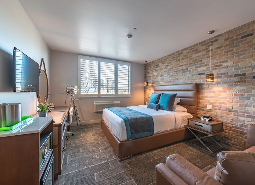 Lexen Hotel - North Hollywood Near Universal Studios guest room in Los Angeles with king bed and brick accent wall