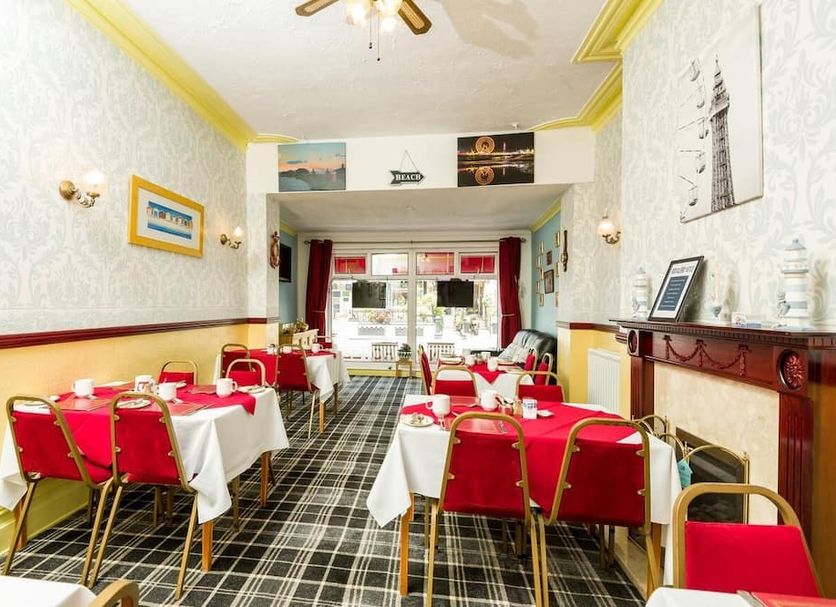 Valdene Hotel Blackpool dining room with red chairs, white tablecloths and checkered carpet