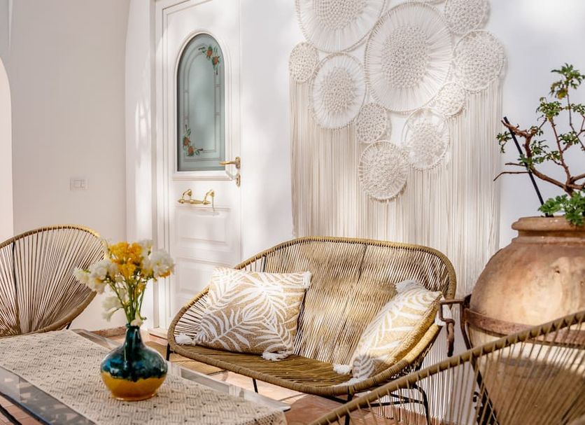B&B Il Sogno in Anacapri lounge with wicker sofa, decorative wall art, flowers and arched door