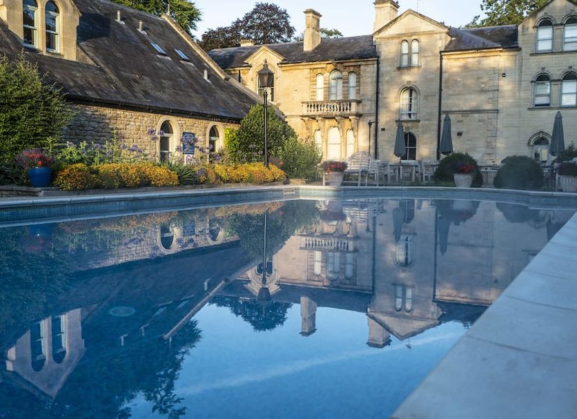 Beechfield House Hotel in Melksham with a reflective outdoor pool and historic stone manor exterior