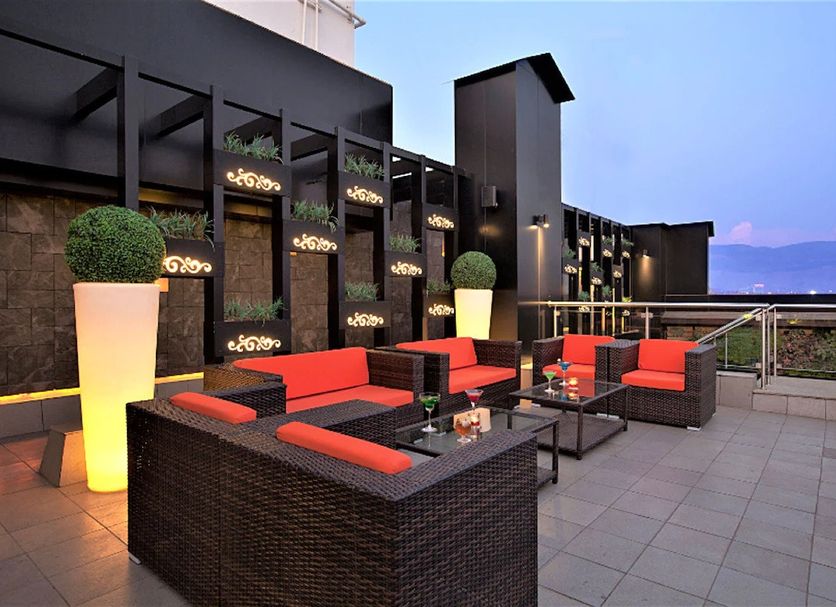 Yogi Executive, Navi Mumbai rooftop lounge with red seating and sea view