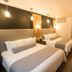 Hotel Marineau Shawinigan guest room with two beds, desk, and warm wood accents in Shawinigan