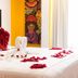 Hotel Santa Cruz Huatulco room with swan towel art, rose petals and red accent pillows
