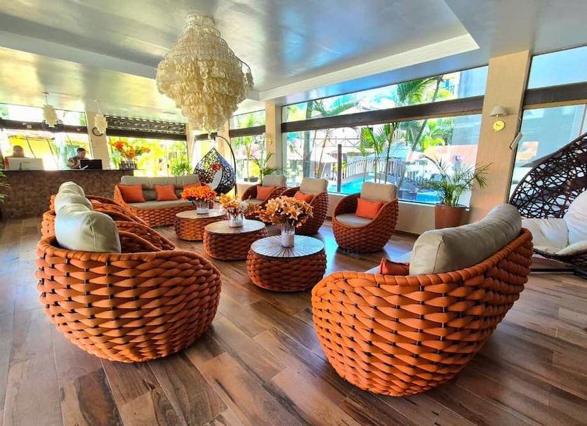 Pousada Recanto do Lobo in Porto de Galinhas lounge with woven chairs, hanging swing, and poolside view