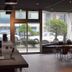 Noboribetsu Guest House Aka & Ao lounge with large windows, café tables and a street view in Noboribetsu