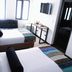 Hotel DC Feria Bogotá guest room with two beds, wall-mounted TV, and dark-framed windows