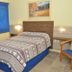 Hotel Blue Star II room in Foz do Iguaçu with twin bed, blue curtains and wall art