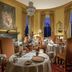 Crossbasket Castle dining room in Glasgow with round-set tables, ornate decor and tall windows