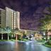 Hilton Grand Vacations Club Parc Soleil Orlando exterior at night with palm trees and lit resort tower
