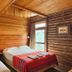 Hosteria Posta de los Colonos in Villa La Angostura: cozy wood-paneled guest room with two beds and window view