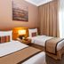 Flora Park Deluxe Hotel Apartments in Dubai, twin guest room with bedside lamp and curtains
