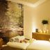 Flair Hotel Nieder in Bestwig spa room with massage table, candles, towels and forest wall mural