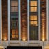 The Cura Hotel Kensington, London, a Tribute Portfolio Hotel exterior with lit windows and entrance awning