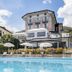 Hotel Asnigo in Cernobbio with outdoor pool, loungers and hillside hotel facade