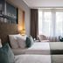 Leonardo Royal Hotel Düsseldorf Königsallee guest room with twin beds, desk and city-view window in Düsseldorf