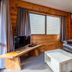 Tasman Holiday Parks - Coromandel lounge with leather sofa, TV, coffee table and wood-paneled walls