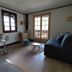 Chalet Appart'Hôtel l'Eau Vive apartment with sofa, bar table and balcony doors in Saint-Nicolas-la-Chapelle