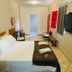 Hospedagem Central in Tiradentes: simple guest room with bed, wall-mounted TV and patterned tile floor