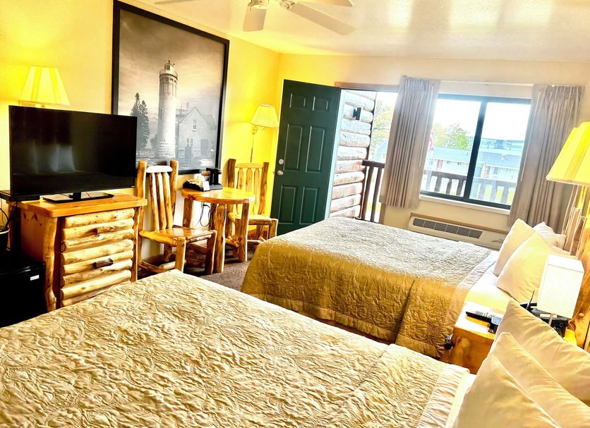 Super 8 by Wyndham Bridgeview of Mackinaw City room with two beds, TV, and balcony view in Mackinaw City