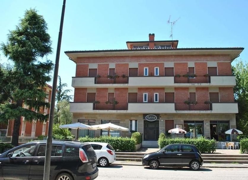Albergo 'da Mario' in Pianoro, street view of a three-story hotel with balconies and parked cars