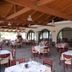 Hotel Kanali in Kanali: covered outdoor restaurant terrace with set tables and red chairs