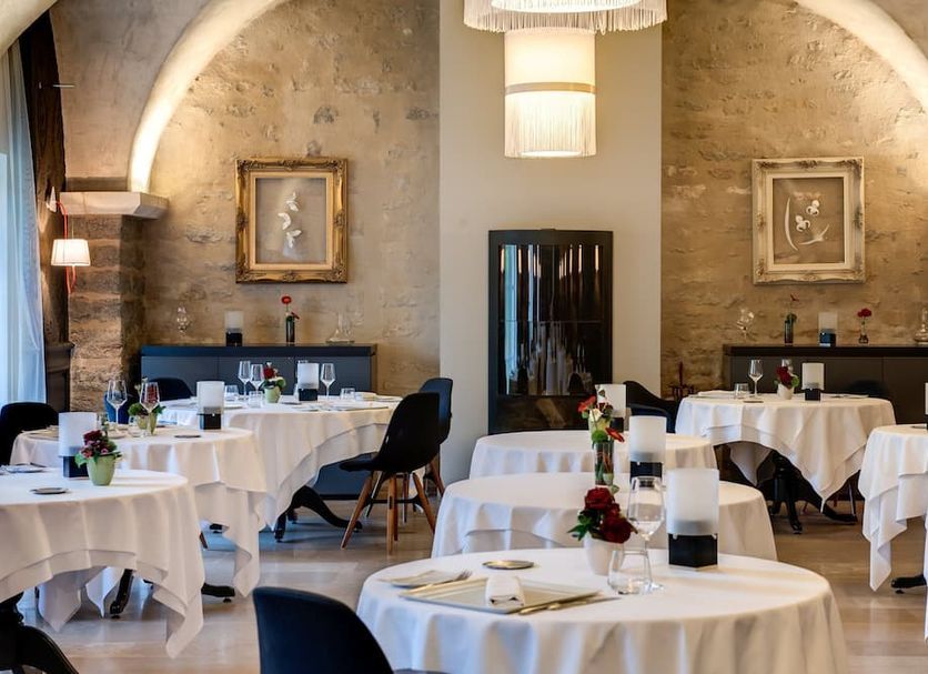 Chateau de Saulon dining room in Saulon-la-Rue with round tables set under arched stone ceilings