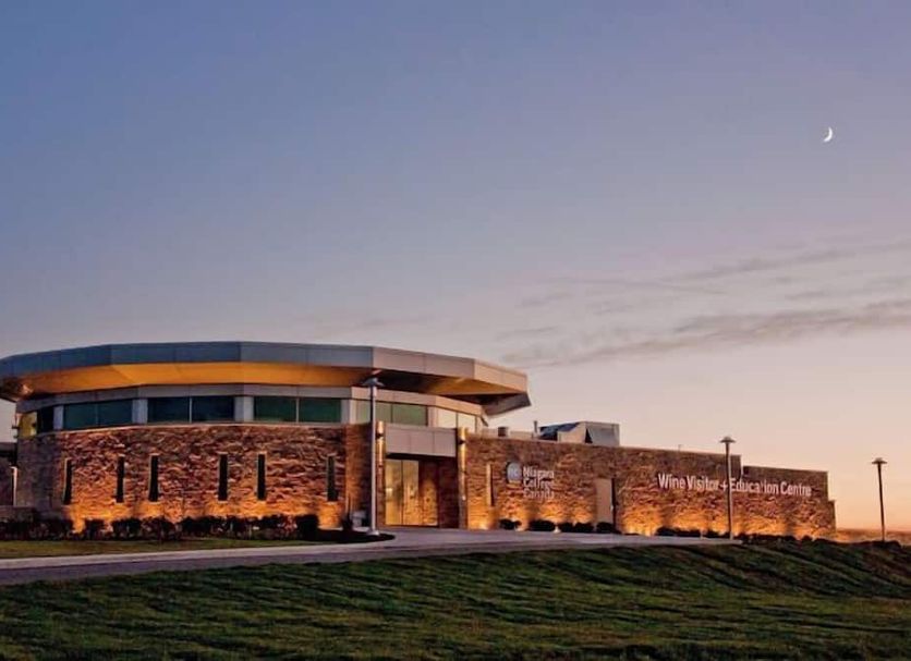 Residence & Conference Centre - Niagara-on-the-Lake exterior at dusk with stone facade and curved roof