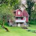 Drottning Victorias Hotell & Vilohem in Borgholm, red house-style hotel amid green trees and lawn