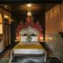 Casa Nostra Boutique Hotel in Paraty: ornate bedroom with carved headboard, bed, and patterned wall