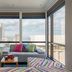 Aloft Panama Panama City suite with city view, sofa, colorful ottoman, and floor-to-ceiling windows