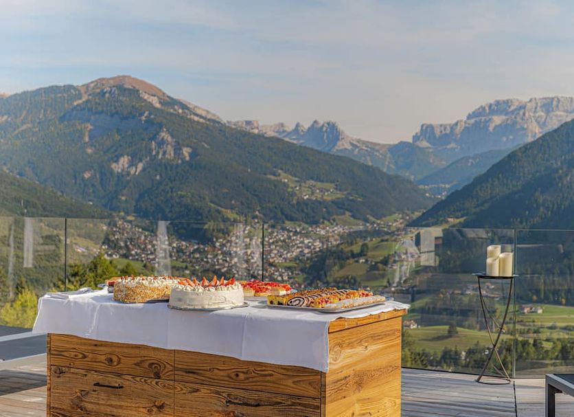 Hotel Scherlin in Ortisei terrace dining table with mountain valley and alpine views