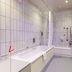 Premier Inn Rugeley bathroom with bathtub, shower screen, toilet and grab rails