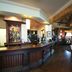 Premier Inn Milton Keynes South lobby bar with wooden counter, seating area and exposed beams in Milton Keynes