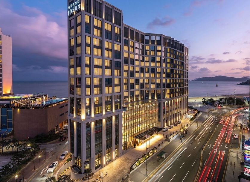 Grand Josun Busan hotel tower at dusk with ocean and city street views in Busan