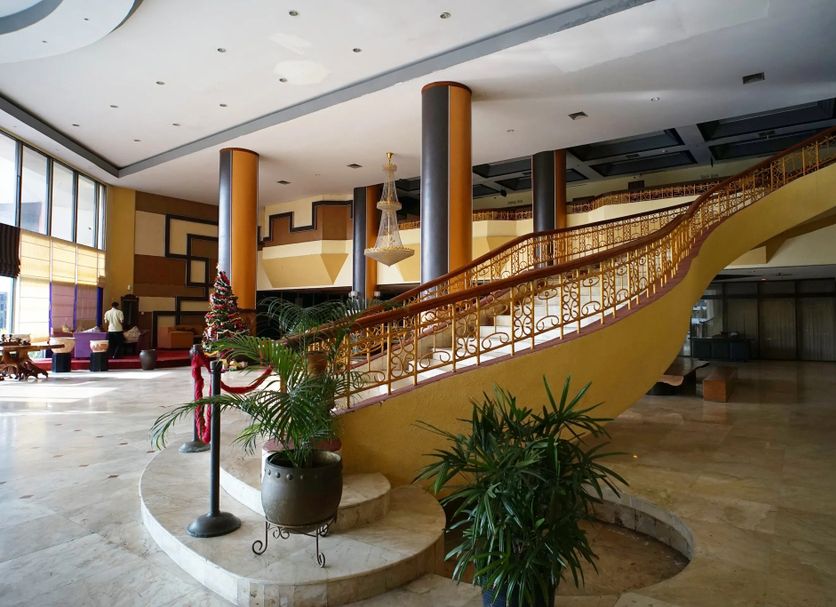 Benakutai Hotel and Apartemen Balikpapan lobby with sweeping curved staircase