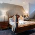 The Coed-Y-Mwstwr Hotel in Bridgend bedroom with four-poster bed and patterned window blind