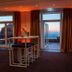 Berggasthof Königstuhl in Heidelberg lounge with tables and open doors to a balcony overlooking sunset sky