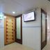 Garden Guest House Hong Kong hallway with doors, wall-mounted TV and glossy tile floors