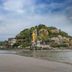 Resort De Paskani in Hua Hin with beachfront view of a rocky hill and sea under cloudy skies