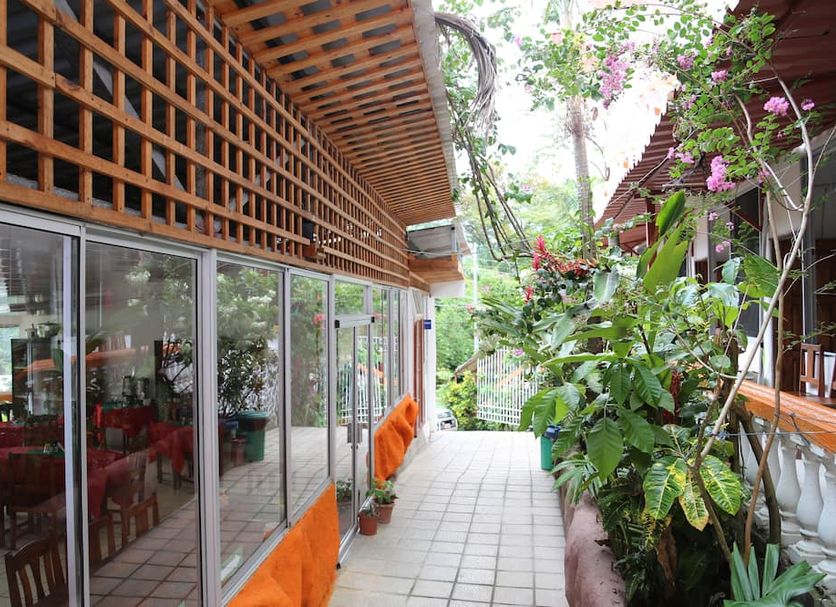 Hotel Coco Beach in Manuel Antonio: tropical garden walkway beside glass-walled dining area