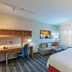 TownePlace Suites by Marriott Tulsa North/Owasso room with bed, sofa, desk and large window in Owasso