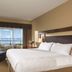 The Beach Club Resort, Parksville: guest room with king bed, armchair, and ocean-view balcony