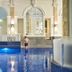 Indoor pool at The Dilly in London with arched windows and blue-tiled water