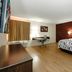 Red Roof Inn Hillsville guest room with king bed, desk, wood floors, and window with curtains