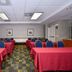 Meeting room at Comfort Inn Southwest Fwy at Westpark in Houston with tables, blue chairs and red tablecloths