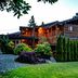 Tigh-Na-Mara Seaside Spa Resort in Parksville, log-style lodge with lit balcony and landscaped garden