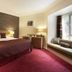 The Manor House At Celtic Manor in Newport guest room with king bed, red carpet, and window seat