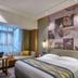 Henan Sky-Land Gdh Hotel in Zhengzhou guest room with bed, desk, window seat and city view