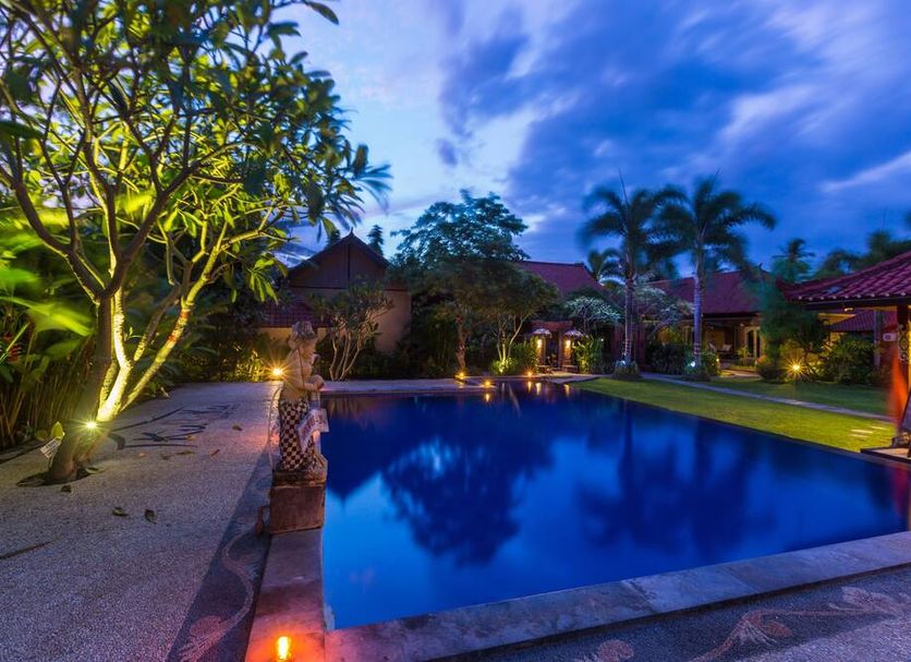 Kubuku Eco Dive Lodge and Yoga in Gerokgak, illuminated poolside scene at dusk with palm trees